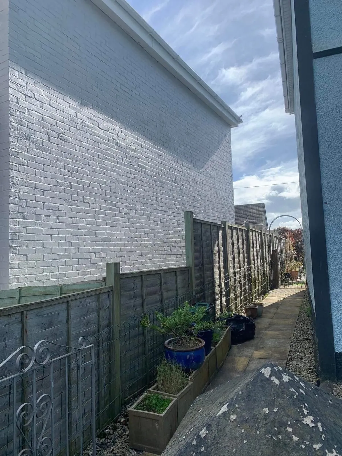 Freshly painted brick wall after preparation and masonry paint in Sidmouth